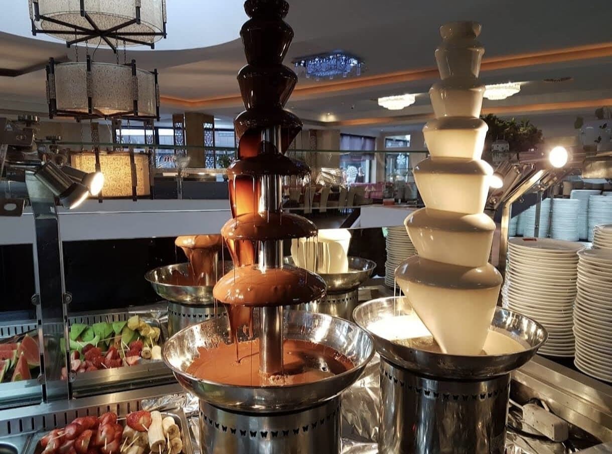 Schokoladenbrunnen mit dunkler und weißer Schokolade am Dessertbuffet